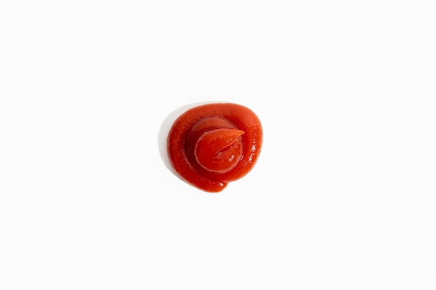 O molho vermelho de ketchup é derramado sobre um fundo branco Vista superior plana