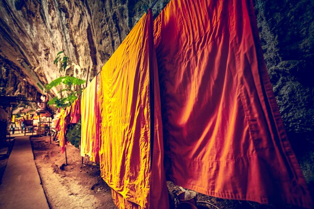 O monge veste a secagem na corda na caverna.