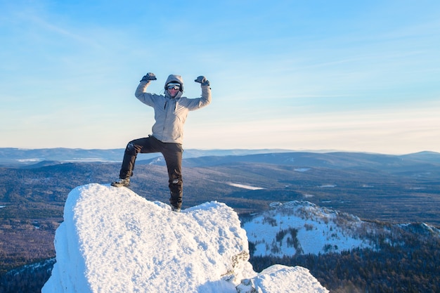 Foto o montanhista escalou o topo da montanha, homem alpinista em pé no pico da rocha e comemora o sucesso