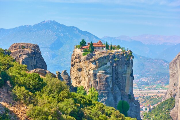 O mosteiro ortodoxo da Santíssima Trindade na falésia em Meteora, Grécia - cenário grego