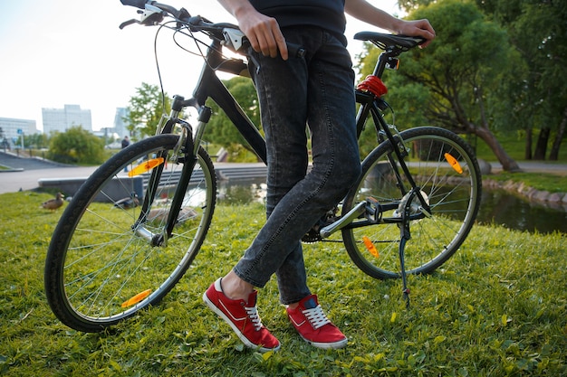 O motociclista parou em um parque da cidade tendo como pano de fundo o pôr do sol