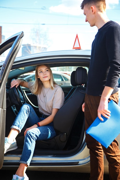 O motorista é um instrutor de escola de automóveis e uma aluna em um carro de exame