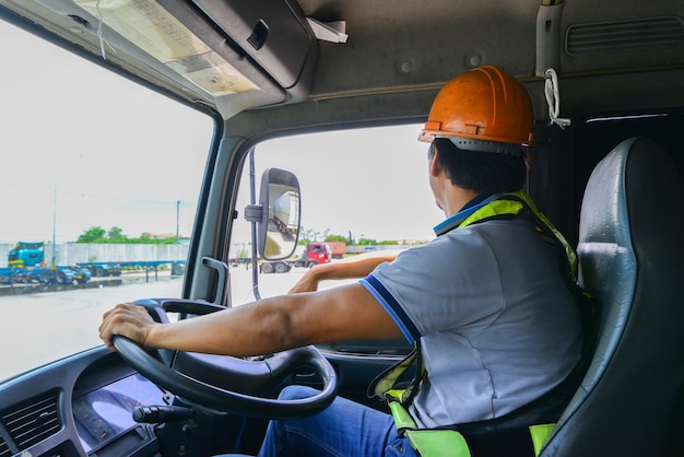 Foto o motorista está verificando o veículo antes de viajar para o site do cliente