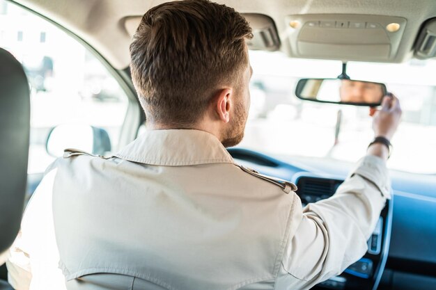 O motorista se olha no espelho retrovisor