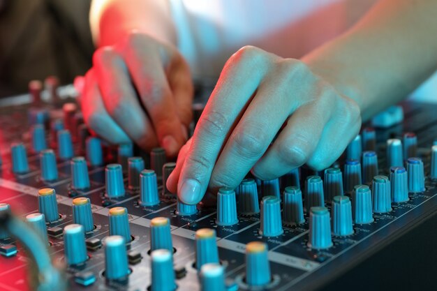 O músico ajusta o som no mixer de áudio