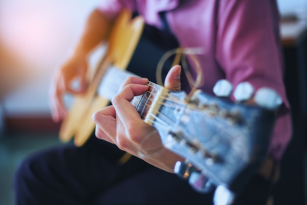 O músico está curtindo o violão. Foco nos dedos