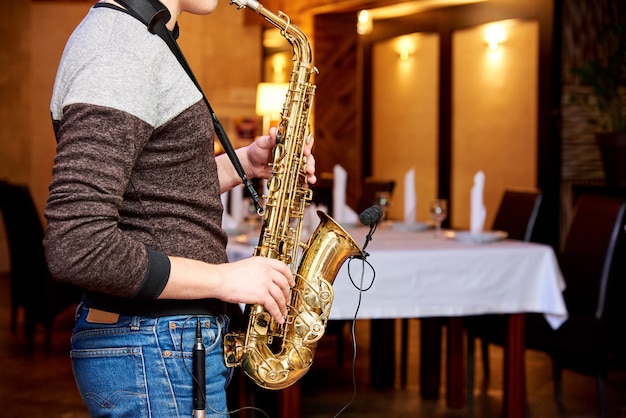 O músico toca saxofone em um restaurante aconchegante.