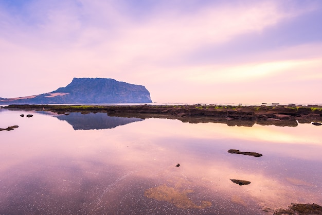 O nascer do sol de Jeju faz a cidade em Seongsan Ilchulbong, ilha de Jeju, Coreia do Sul.