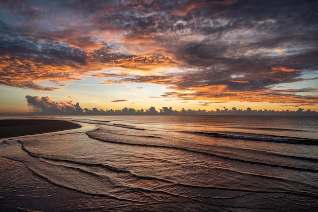 O nascer do sol disparou sobre o mar e uma bela nuvem.