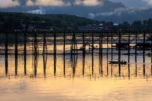 O nascer do sol ou a luz da manhã Mon Bridge é a longa ponte de madeira