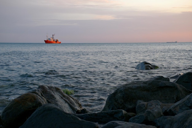 O navio contra o fundo de nuvens cor de rosa ao pôr do sol navega nas ondas Noite de verão Linda paisagem de conto de fadas Mar Negro Rússia