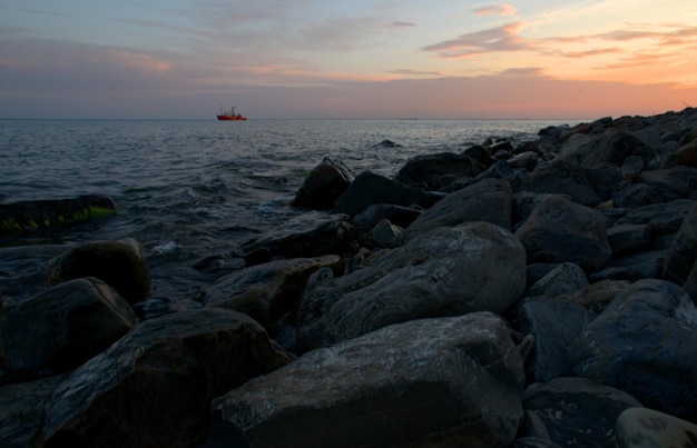 O navio contra o fundo de nuvens cor de rosa ao pôr do sol navega nas ondas Noite de verão Linda paisagem de conto de fadas Mar Negro Rússia