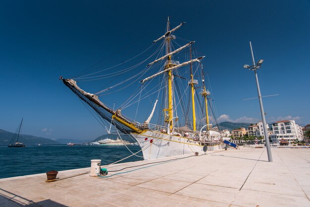 O navio está atracado no cais com as velas abaixadas