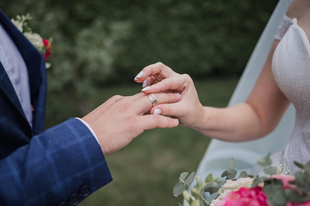O noivo coloca um anel no dedo da noiva