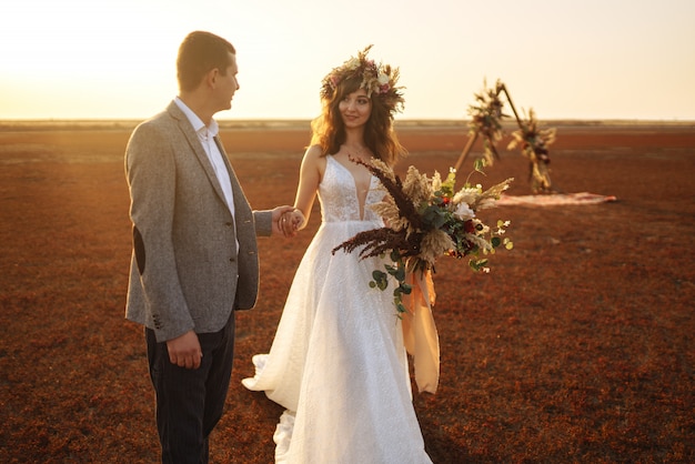 O noivo e a noiva jovem e bonita se amam. dia do casamento no estilo boho.