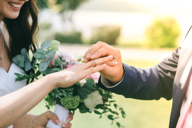 O noivo veste a noiva um anel de casamento na cerimônia.