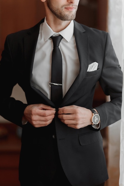 O noivo vestido com estilo se prepara para a cerimônia de casamento A manhã do noivo O empresário usa um casaco As mãos do homem em close-up O noivo se preparando na manhã antes da cerimônia de casamento