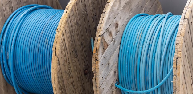 O novo cabo de alimentação azul é enrolado na bobina de madeira Fundo