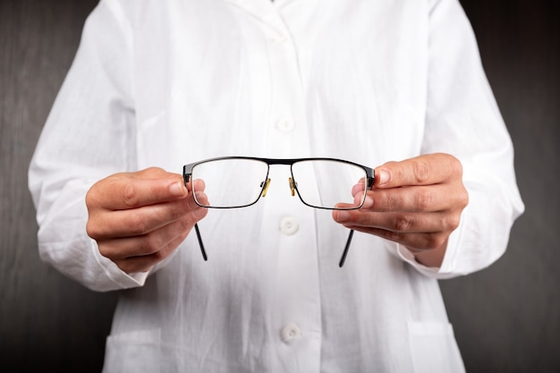 O oftalmologista oferece óculos para a saúde ocular do paciente