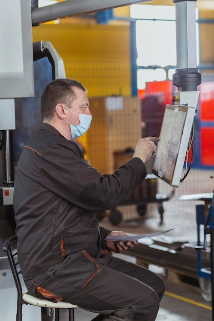 O operador ajusta uma máquina cnc na fábrica