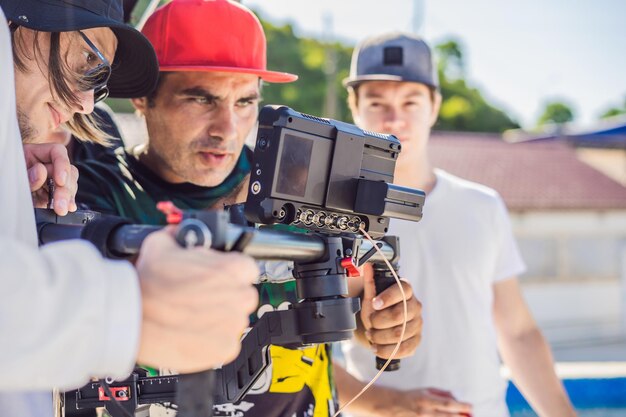 O operador da Steadicam e seu assistente preparam a câmera e o estabilizador de 3 eixos para uma filmagem comercial