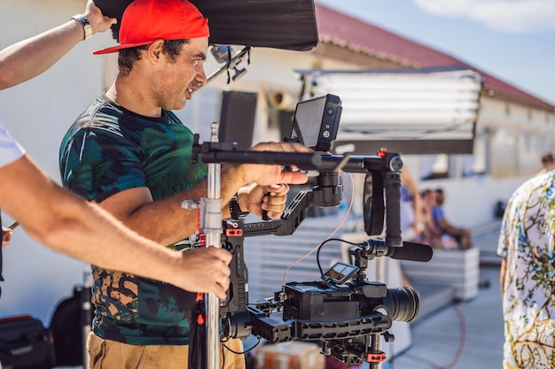 O operador da Steadicam prepara a câmera e o estabilizador de 3 eixos para uma filmagem comercial