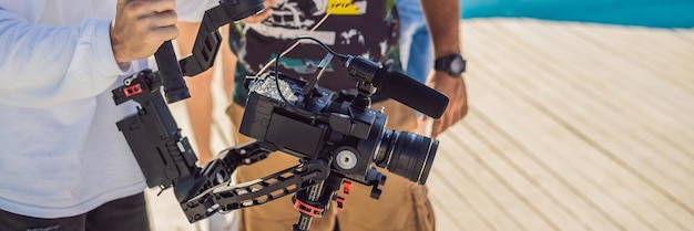 O operador profissional de steadicam usa um sistema estabilizador de câmera de eixo em um conjunto de produção comercial