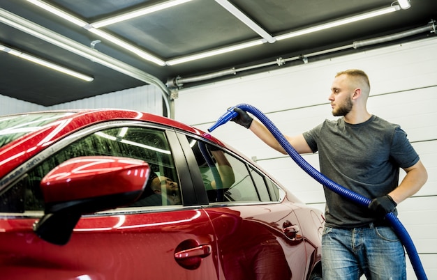 O operário faz a secagem automática do carro após a lavagem.