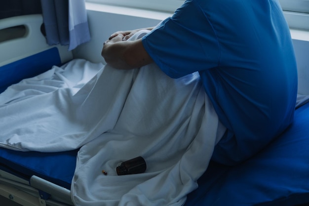 O paciente sentou-se na cama e olhou pela janela do hospital sozinho e teve estresse, tédio, solidão, ansiedade Cuidados de saúde e assistência médica