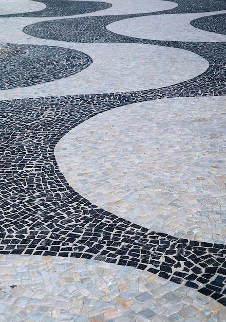 Foto o padrão de ondas do pavimento português na praia de copacabana no rio de janeiro, brasil