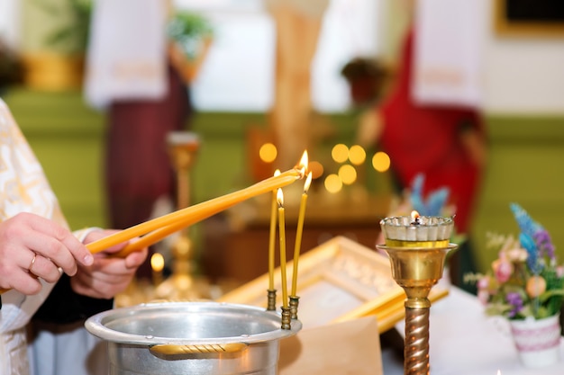 O padre acende velas na igreja ortodoxa