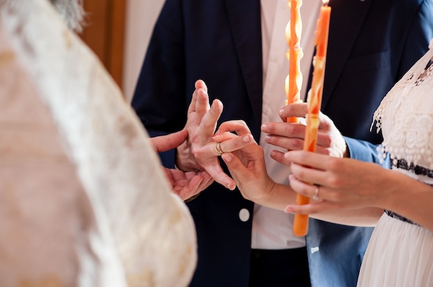 Foto o padre veste os anéis para os noivos.