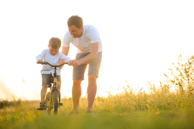 O pai ajuda seu filho a andar de bicicleta