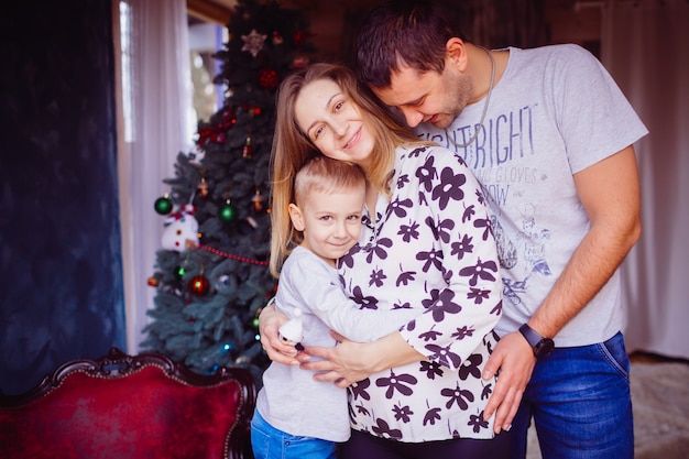 O pai e a mãe abraçando seu filho