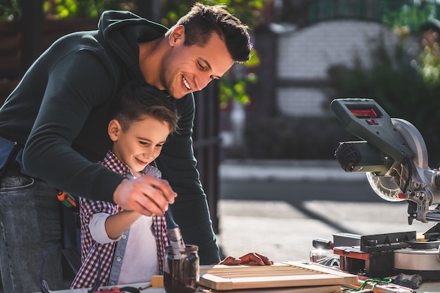 Foto o pai e o filho pintam carpintaria juntos