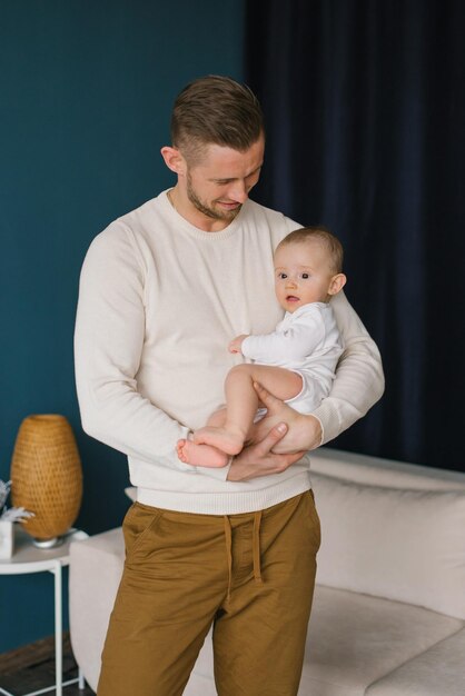 Foto o pai está segurando um bebê em seus braços ambos estão vestidos com roupas casuais família dia dos pais