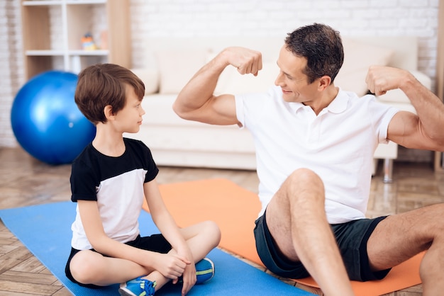 O pai mostra ao filho seus músculos.