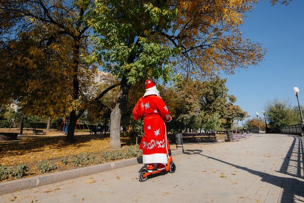 O Pai Natal tem pressa numa scooter com presentes para as crianças no feriado.