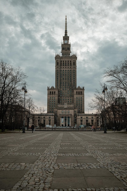 Foto o palácio da ciência e cultura de varsóvia contra o fundo do céu nublado