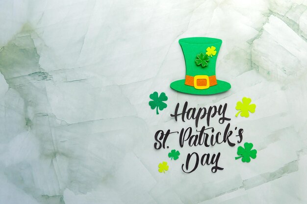 O papel do Happy St. Patrick cortou as letras com o chapéu do duende e o trevo no fundo. Cartão de saudação do dia de Saint Patricks. Espaço para texto. Foco suave. Vista do topo.