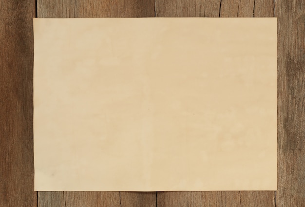 O papel vazio velho no assoalho de madeira do vintage e tem o espaço da cópia.