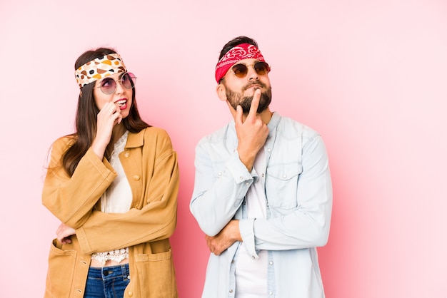 O par caucasiano novo que veste uma roupa de um festival de música isolou o pensamento relaxado sobre algo que olha um espaço da cópia.