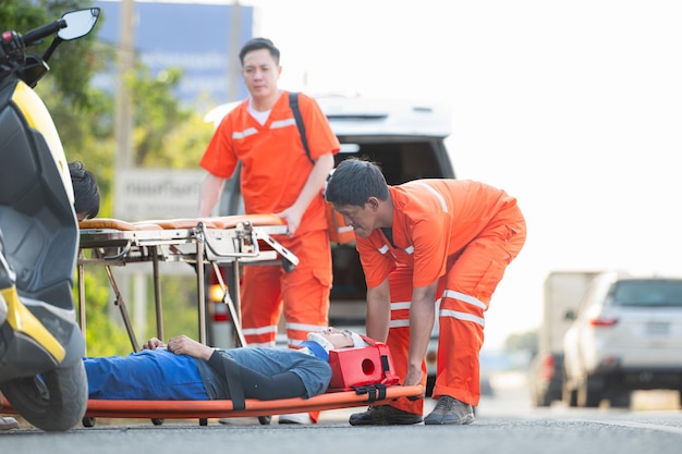 O paramédico está ajudando um homem ferido em uma situação de emergência na estrada