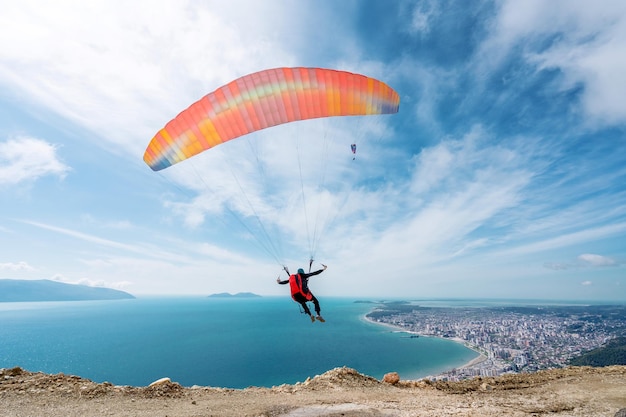 O parapente está começando o paraquedas está se enchendo de ar nos Alpes das montanhas em um dia ensolarado na Albânia