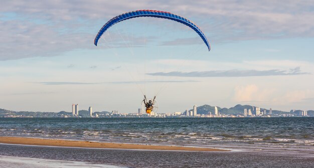 Foto o parapente voa no céu acima do mar