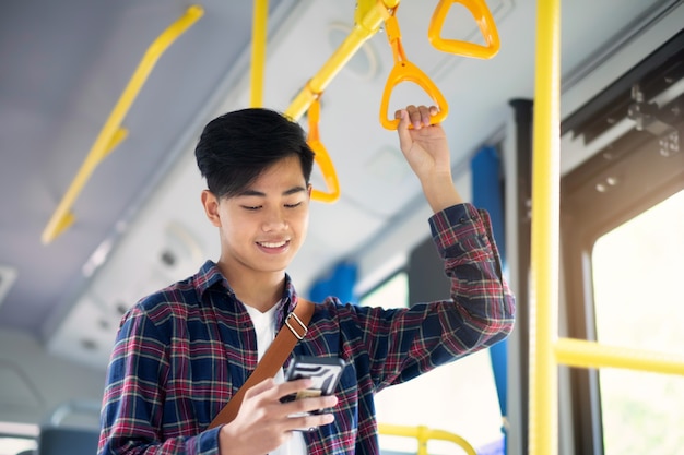 O passageiro usando o celular no ônibus público.