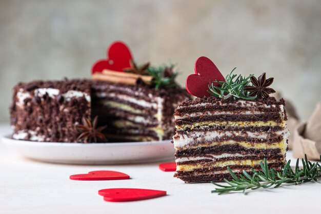 O pedaço de bolo com camadas de chocolate e corações vermelhos