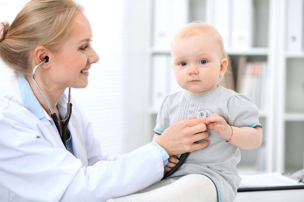 O pediatra está cuidando do bebê no hospital A garotinha está sendo examinada pelo médico com estetoscópio