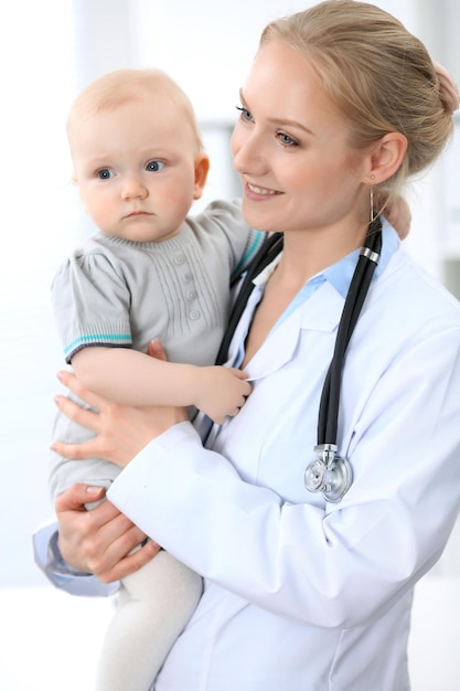 O pediatra está cuidando do bebê no hospital A garotinha está sendo examinada pelo médico com estetoscópio