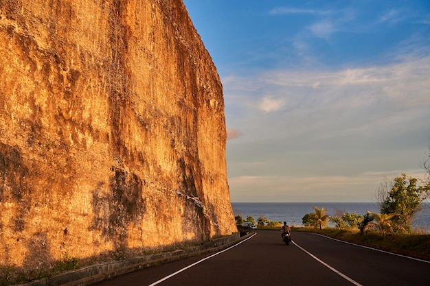 O penhasco sobressai ao longo da estrada para o oceano ao pôr-do-sol